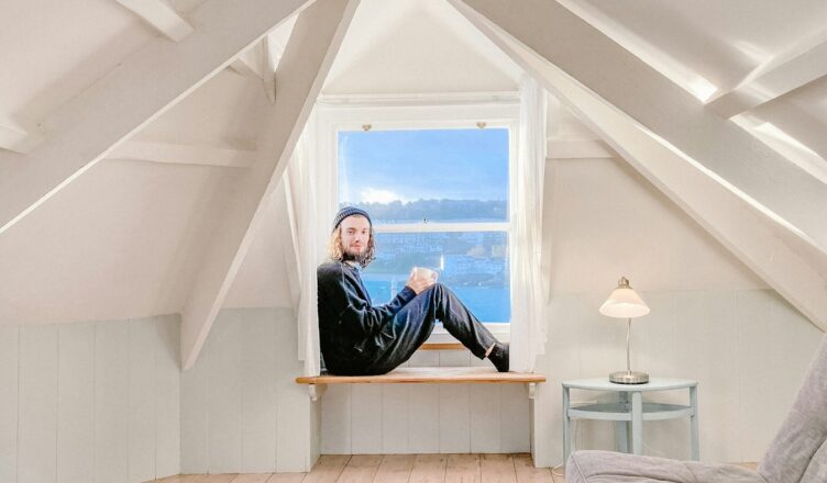 man in black jacket sitting on bed